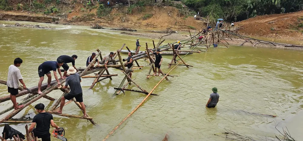 Hundratals människor mobiliserades för att bygga en tillfällig bambubro över Huoi Nguyen-bäcken. Hàng trăm người được huy động xây dựng cầu tạm bằng tre nứa vượt khe Huồi Nguyên.jpg