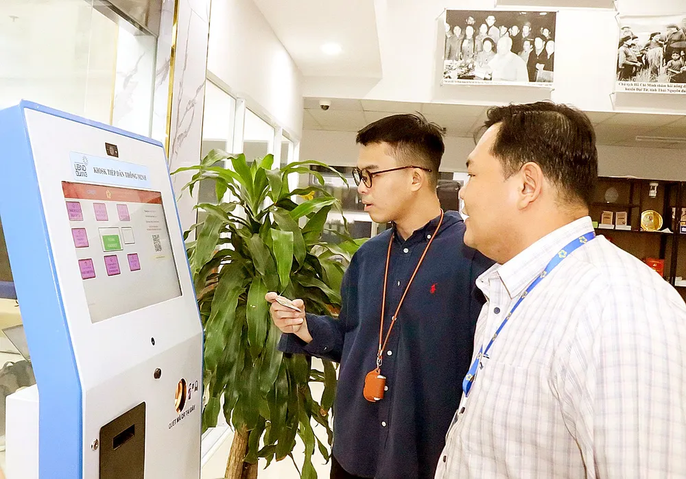 Công chức phường Xuân Hòa (TPHCM) hướng dẫn người dân thực hiện các bước giao dịch hồ sơ trên cổng thông tin trực tuyến. Ảnh: THÁI PHƯƠNG Y1a.jpg