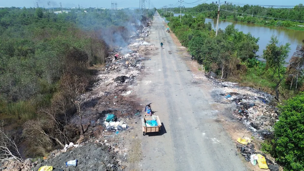 Nhiều người dân nhặt phế liệu từ các bãi rác tự phát ven đường