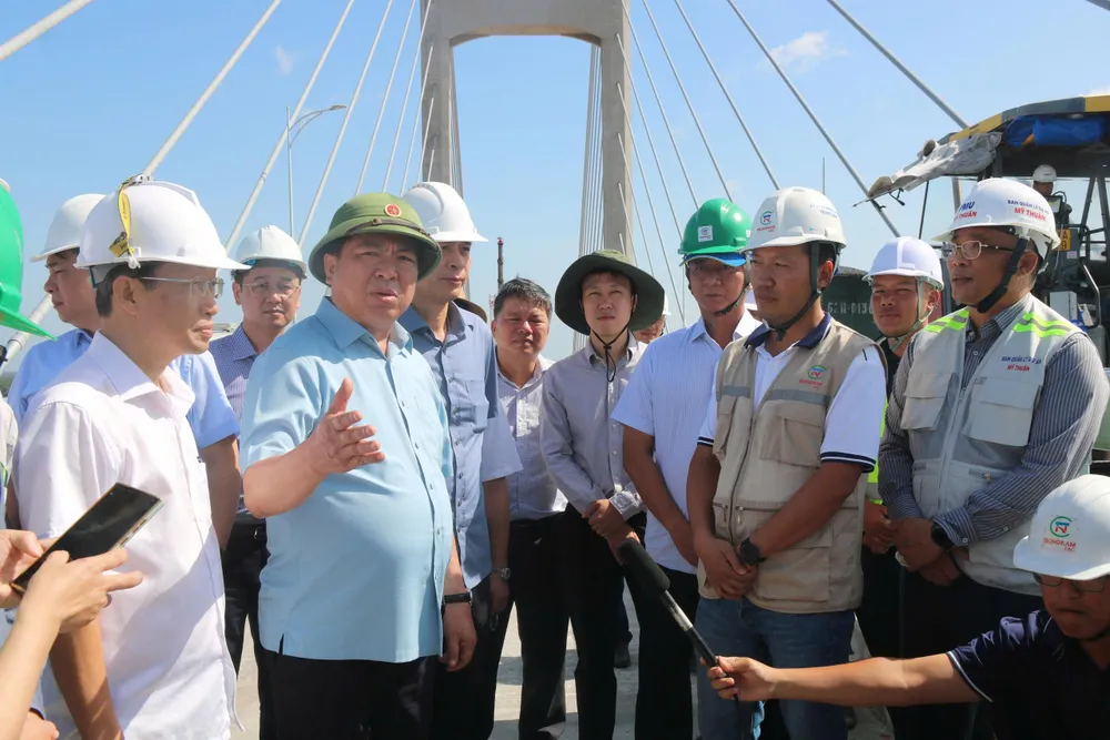 Thứ 2 từ trái sang, Bộ trưởng Bộ Xây dựng Trần Hồng Minh kiểm tra tiến độ thi công của dự án cầu Rạch Miễu 2 - Ảnh: Thạch Thảo ảnh 3.jpg