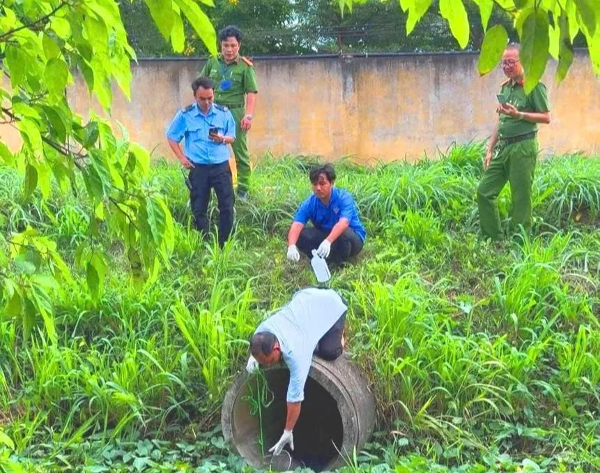 Đoàn kiểm tra đang tiến thu mẫu nước thải của công ty. Ảnh: Cẩm Tú ảnh 1.jpg