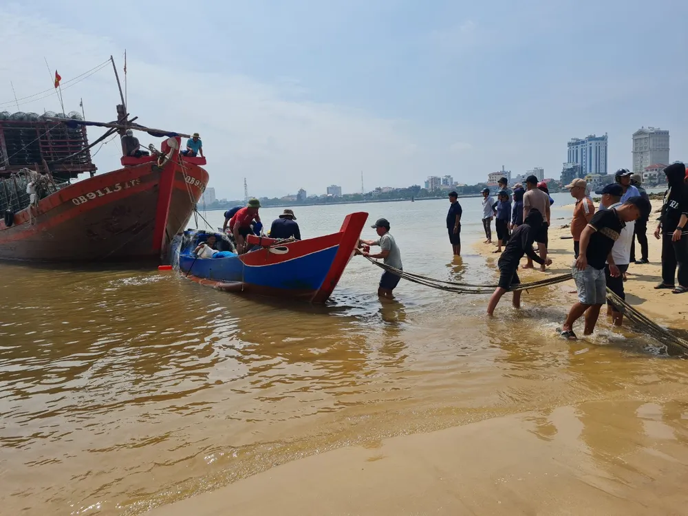 Ngư dân lai dắt tàu đánh cá bị chìm vào bờ Ngư dân lai dắt tàu đánh cá bị chìm vào bờ