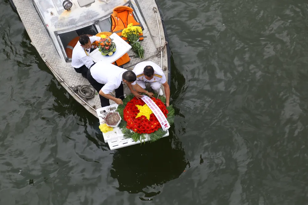 Sau lễ dâng hương, đồng đội cùng người thân thực hiện nghi thức thả vòng hoa về cửa biển để tưởng nhớ các chiến sĩ đã hy sinh để bảo vệ Tổ quốc. Ảnh: PHẠM NGA