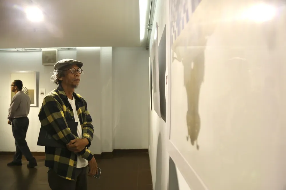 Khách tham quan trầm tư với các tác phẩm tại triển lãm. Ảnh: PHẠM NGA Khách tham quan trầm tư với các tác phẩm tại triển lãm. Ảnh: PHẠM NGA