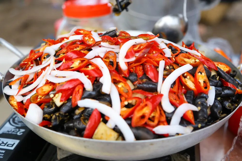 Chị Nguyễn Thị Ngọc Hân (quận Liên Chiểu) cho biết: &quot;Việc hình thành Phố ăn vặt Nam Ô trong mùa du lịch là rất hợp lý, vừa tạo được sinh kế cho bà con vừa góp phần làm mới hình ảnh của thành phố trong mắt du khách khi đến với Đà Nẵng&quot;. Ảnh: PHẠM NGA