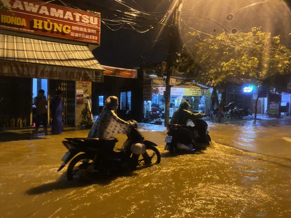 Người dân chật vật đẩy xe qua dòng nước lũ chảy xiết Người dân chật vật đẩy xe qua dòng nước lũ chảy xiết
