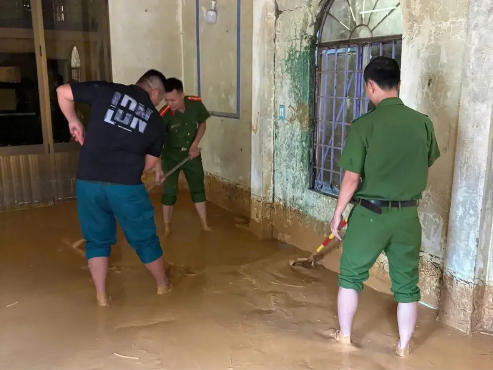 Lực lượng chức năng hỗ trợ người dân dọn dẹp sáng 6-7. Ảnh: Công an TP Đà Nẵng z6777037406433_a3687346109dbe3320a3c9bc7aacb48a.jpg
