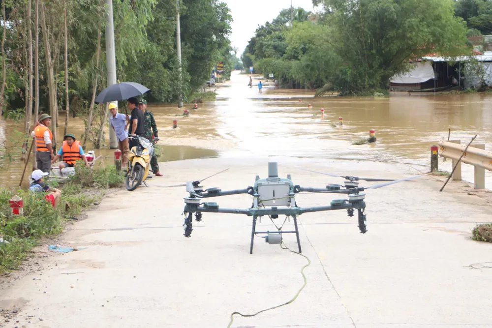 Drone mang nhu yếu phẩm đến với bà con vùng lũ Đà Nẵng. Ảnh: PHẠM NGA z7170894634952_cc38b57f888ebcfe0e3a0864bb34544f.jpg