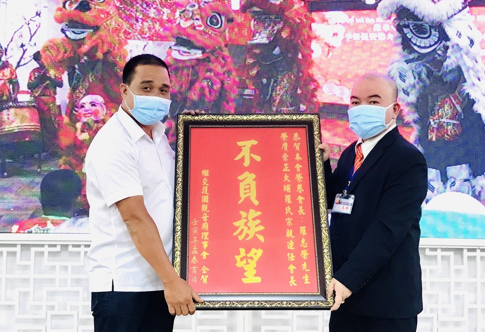 　　繼交護國觀音廟理事會交際謝振廣（左）向 羅志榮理事長贈送禮物祝賀。