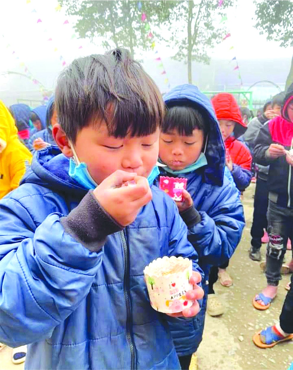 孩子們在嚴寒天氣中津津有味吃著蛋糕。