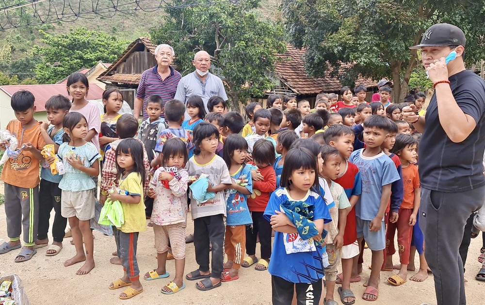 梁肇添、鄭成龍（後排左一、二）和梁志偉（前排右一）向小朋友發送禮物後留影。