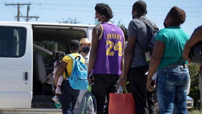 越過美墨邊境的移民在美國得克薩斯州德爾里奧等待上車。 新華社 圖