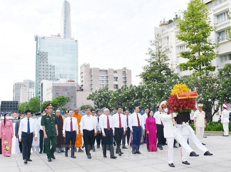 市領導代表團在第一郡阮惠街胡志明主席塑像公園敬獻花籃。