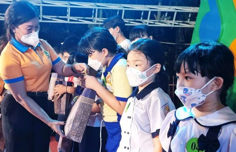 第五郡勞動聯團主席黎氏碧幸向職工的 子弟贈送禮物。