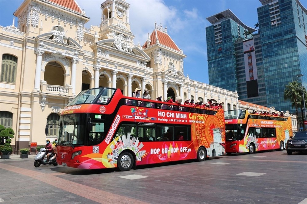 遊客乘坐雙層敞篷車參觀本市。