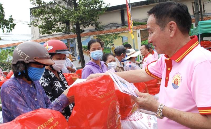 鄭氏宗祠理事長鄭學才向地方貧困者贈送濟貧禮物。