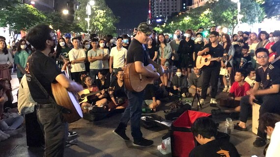 觀眾在阮惠步行街與樂隊進行文化交流。