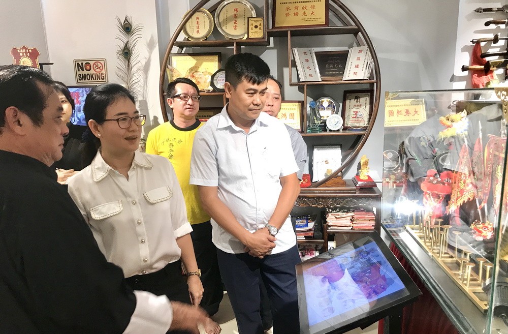 黃志民師傅(左一)向第十一郡領導介紹“傳承閣”。