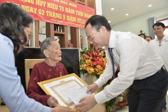 市委副書記阮文孝向鄭氏小頒授75年黨齡紀念章。