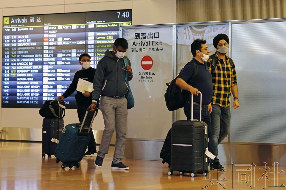 10月11日,旅客從海外抵達東京羽田機場。(圖:共同社)