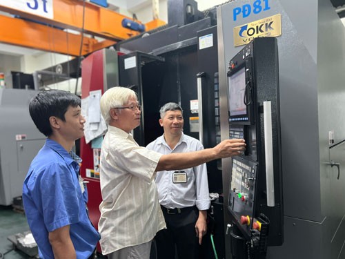 第七郡立福有限责任公司总经理阮文智指引工人操作机器。