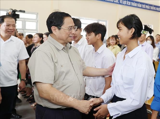 政府总理范明政与少数民族学生交谈。