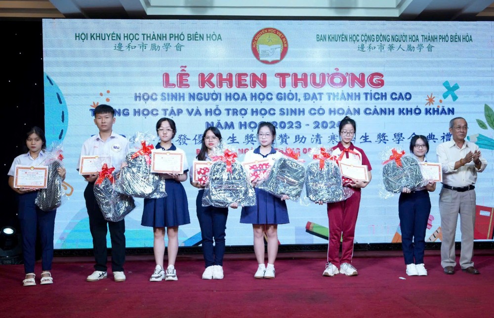 边和华人励学会主任黄友义向优秀生颁奖。