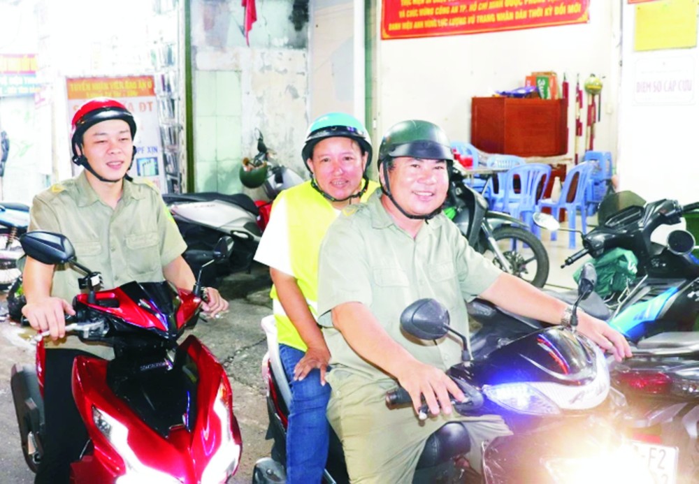 第四郡第十四坊人民巡逻组副组长梅明幸(中)与组员们一起在辖区巡逻。