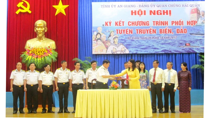 Đại diện Tỉnh ủy An Giang và Quân chủng Hải quân trao văn bản ký kết hợp tác tuyên truyền biển, đảo. Ảnh: NHƯ NGUYỄN