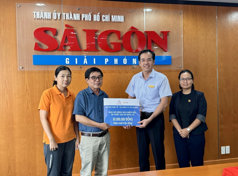 Ông Hồ Viễn Phương, Phó Hiệu trưởng, Chủ tịch Công đoàn UEF trao tiền hỗ trợ đồng bào miền Bắc bị ảnh hưởng bão lũ cho đại diện Báo SGGP. Ảnh: TẤN BA 1000002453.jpg