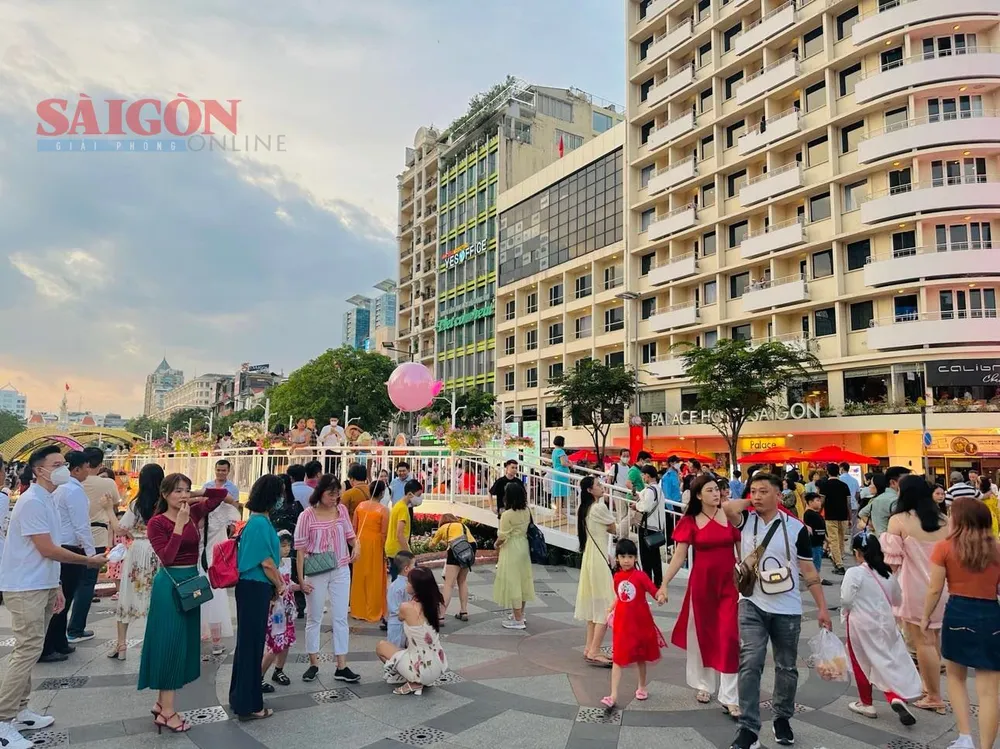 Nhiều người dân và du khách đến đường hoa phố đi bộ Nguyễn Huệ vui chơi, chờ đón giao thừa. Ảnh: TIỂU TÂN