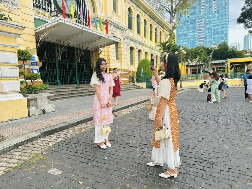 Du khách chụp ảnh trước Bưu điện TPHCM. Ảnh: TIỂU TÂN