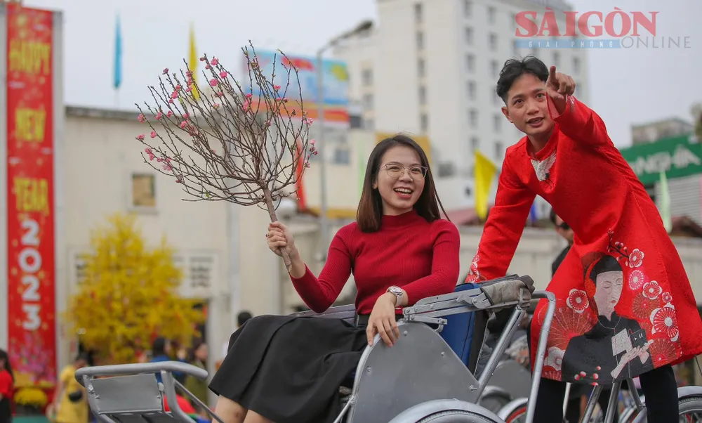 Các bạn trẻ chụp ảnh tết trước chợ Bến Thành. Ảnh: DŨNG PHƯƠNG