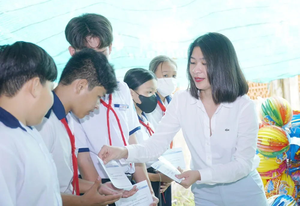Bà Châu Ngọc Minh Châu, đại diện Công ty Amway Việt Nam, trao học bổng cho học sinh. Ảnh: VIỆT NGA