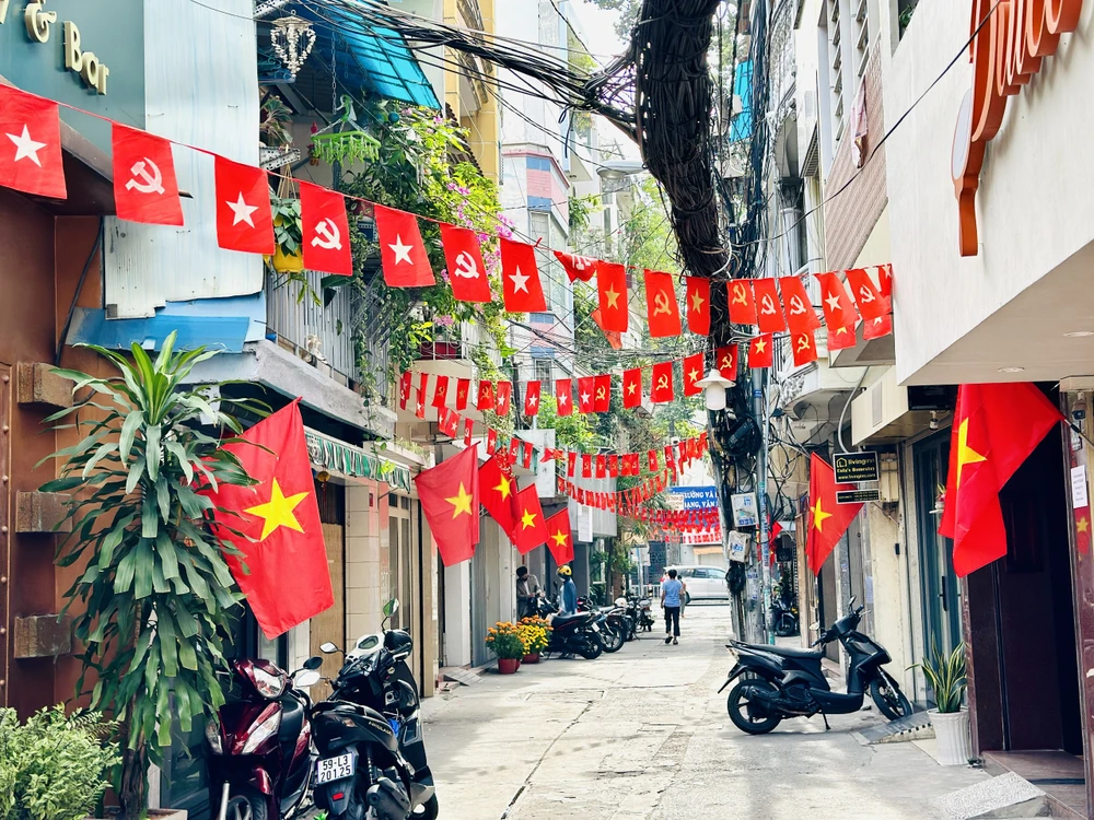 Các tuyến hẻm ở quận 1, quận 3 treo cờ rực rỡ. Ảnh: CHÍ THẠCH z6272041919271_119d4c031e301ff46567faee808b87d2.jpg