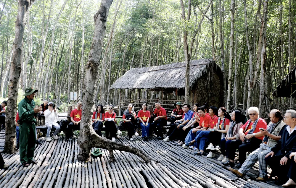 The delegation listened to stories about the Mangrove Forest during the war against the Americans. Ảnh chụp Màn hình 2025-12-16 lúc 14.10.32.png
