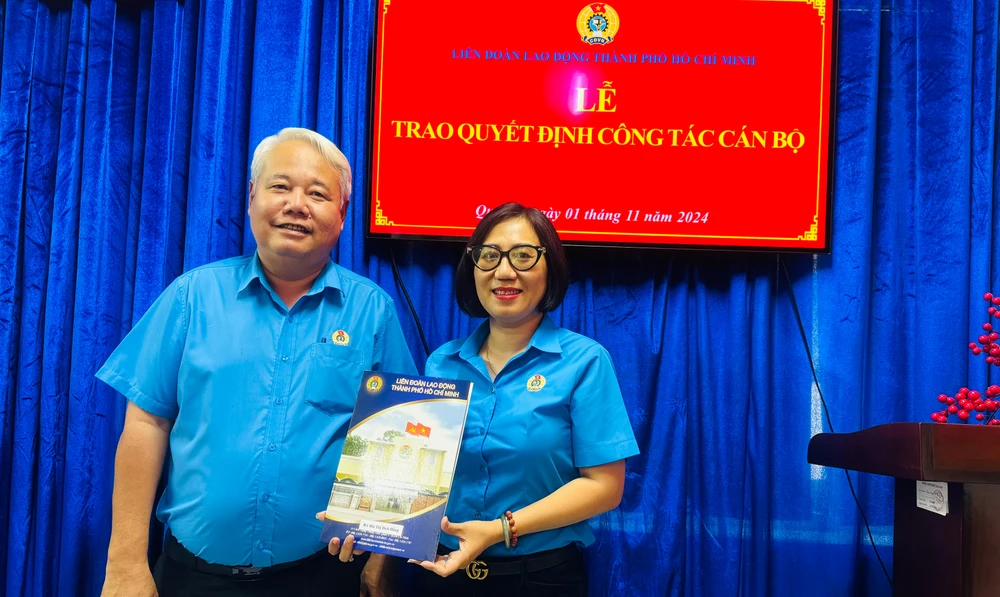 Chủ tịch Liên đoàn Lao động TPHCM Võ Khắc Thái trao quyết định đối với Bùi Thị Bích Hồng. Ảnh: Đình Dư 01.jpg