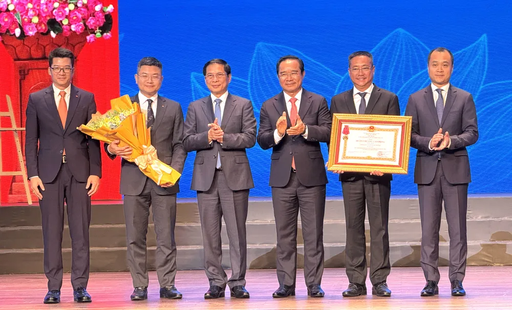 Phó Thủ tướng Chính phủ, Bộ trưởng Bộ Ngoại giao Bùi Thanh Sơn và Chủ tịch UBND TPHCM Nguyễn Văn Được trao tặng Huân chương Lao động hạng Nhất của Chủ tịch nước tại buổi lễ. Ảnh: Đình Dư e329edb7bf3637686e27.jpg