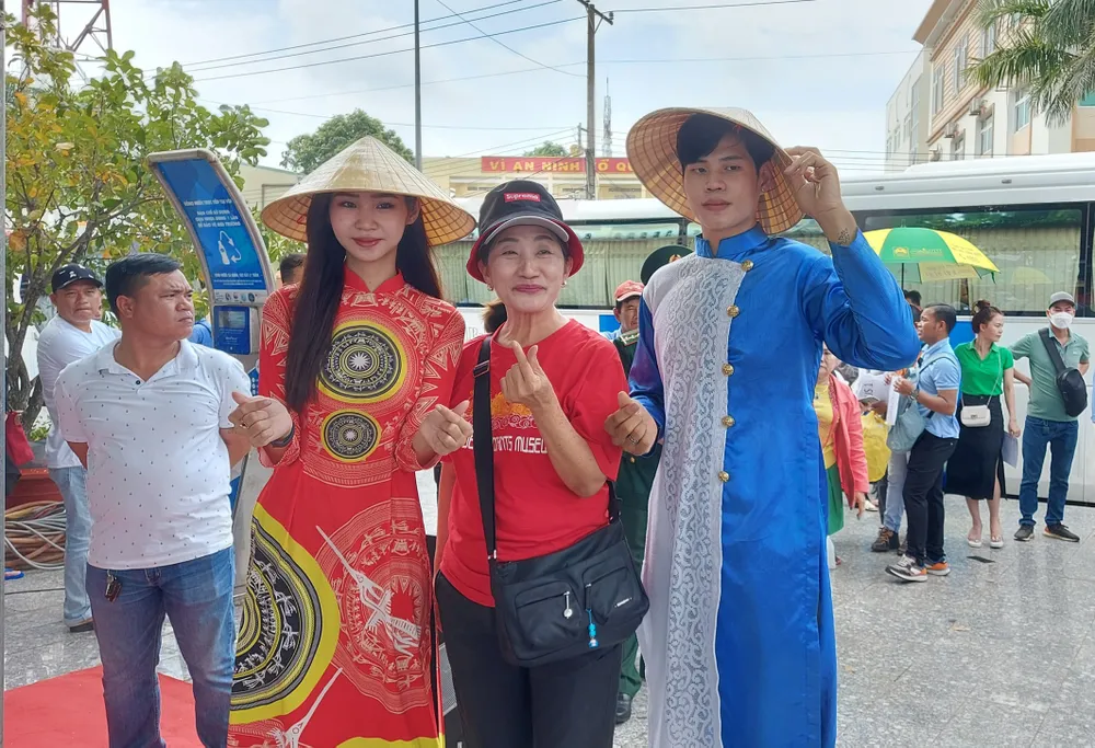 Du khách thích thú chụp ảnh lưu niệm với hướng dẫn viên du lịch trong trang phục truyền thống của Việt Nam. Ảnh: QUỐC BÌNH Du khách thích thú chụp ảnh lưu niệm với hướng dẫn viên du lịch trong trang phục truyền thống của Việt Nam. Ảnh: QUỐC BÌNH