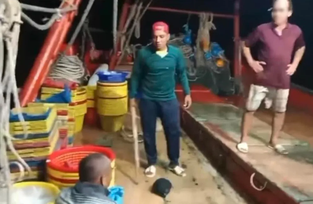Thanh niên dùng cây gỗ đội nón màu cam đánh 2 người trên tàu, trong khi 2 người này chỉ van xin: “Tui lạy ông, ông Mỹ ơi”. Ảnh: CTV Thanh niên dùng cây gỗ đội nón màu cam đánh 2 người trên tàu, trong khi 2 người này chỉ van xin: “Tui lạy ông, ông Mỹ ơi”. Ảnh: CTV