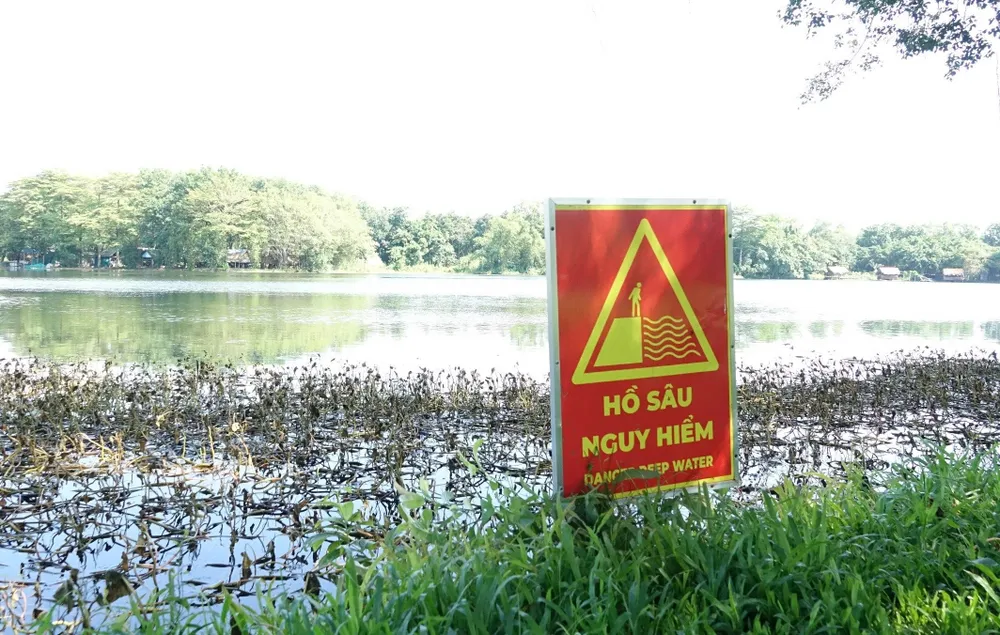 Hồ nuôi cá sấu trong công viên An Hòa đã được gắn biển cảnh báo... độ sâu. Ảnh: QUỐC BÌNH Hồ nuôi cá sấu trong công viên An Hòa đã được gắn biển cảnh báo... độ sâu. Ảnh: QUỐC BÌNH