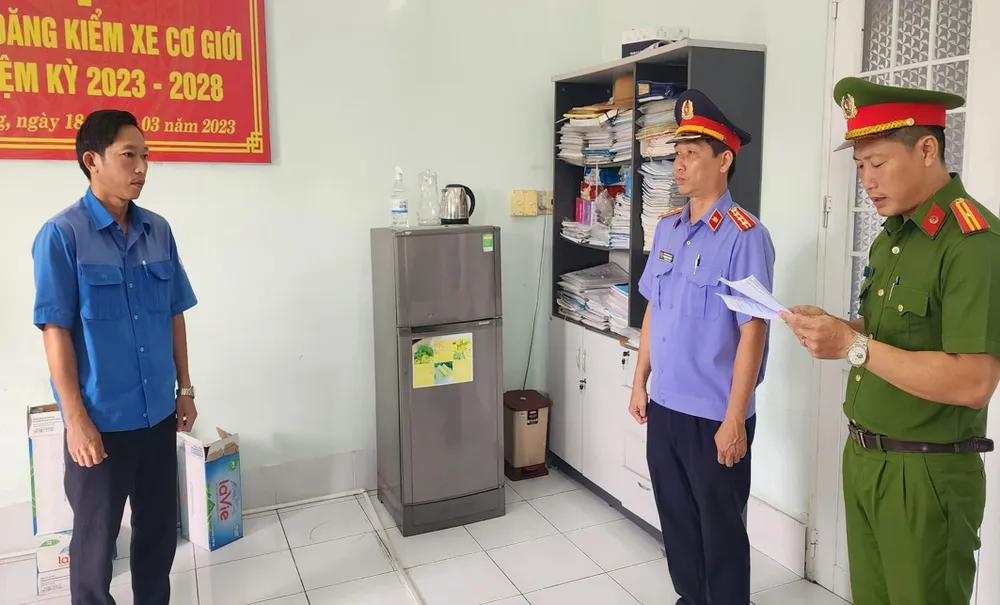 Đặng Phi Long nghe đọc lệnh bắt tạm giam, khám xét nơi làm việc. Ảnh: V.VŨ