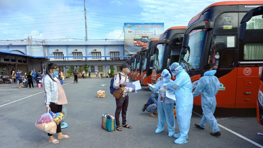 Kiểm tra giấy xét nghiệm Covid-19 trước khi lên xe về quê. Ảnh: QUỐC HÙNG