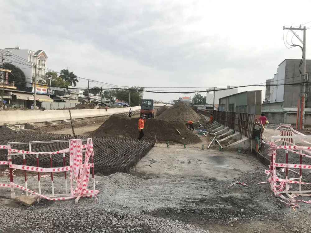 Đơn vị thi công đang khẩn trương hoàn thiện đường hai bên đầu cầu. Ảnh: QUỐC HÙNG