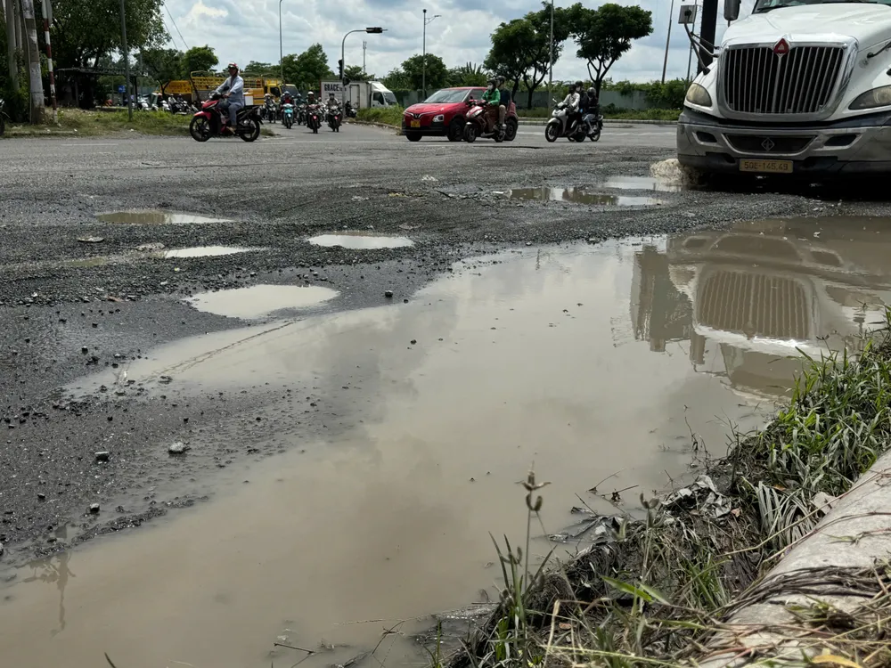 Hai bên đường Nguyễn Văn Linh vẫn đầy ổ gà, ổ voi gây nguy hiểm. Ảnh: QUỐC HÙNG 5lun.jpg