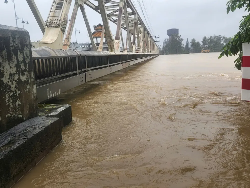 Mực nước đang dâng lên rất cao, gây nguy hiểm đường tàu. Ảnh: VĂN THIỆU 27 tau.jpg