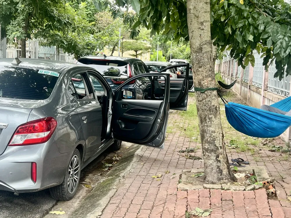 Không chỉ đậu xe sai quy định, một số tài xế còn mắc võng nằm ngủ ngay trên vỉa hè. Ảnh: QUỐC HÙNG 29h.jpg
