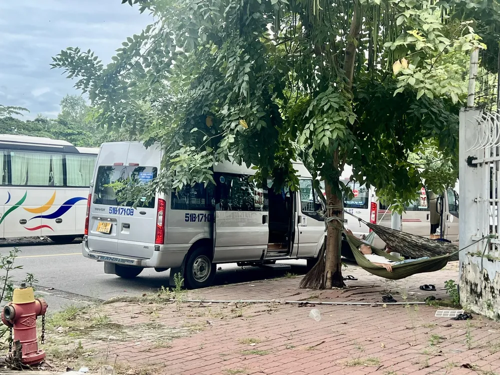 Tài xế đậu xe kín hai bên đường rồi vô tư mắc võng ngủ. Ảnh: QUỐC HÙNG 29h1.jpg