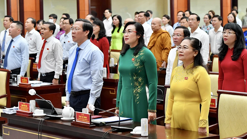 Các đại biểu thực hiện nghi thức Chào cờ trước khi bắt đầu vào các nội dung chính của kỳ họp. Ảnh: VIỆT DŨNG