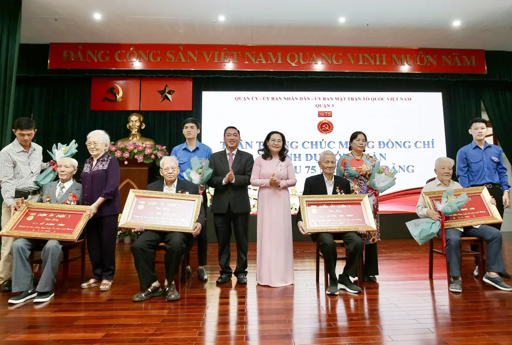 Đồng chí Nguyễn Thị Lệ và đồng chí Phạm Thành Kiên trao Huy hiệu 75 năm tuổi Đảng cho các đảng viên. Ảnh: DŨNG PHƯƠNG